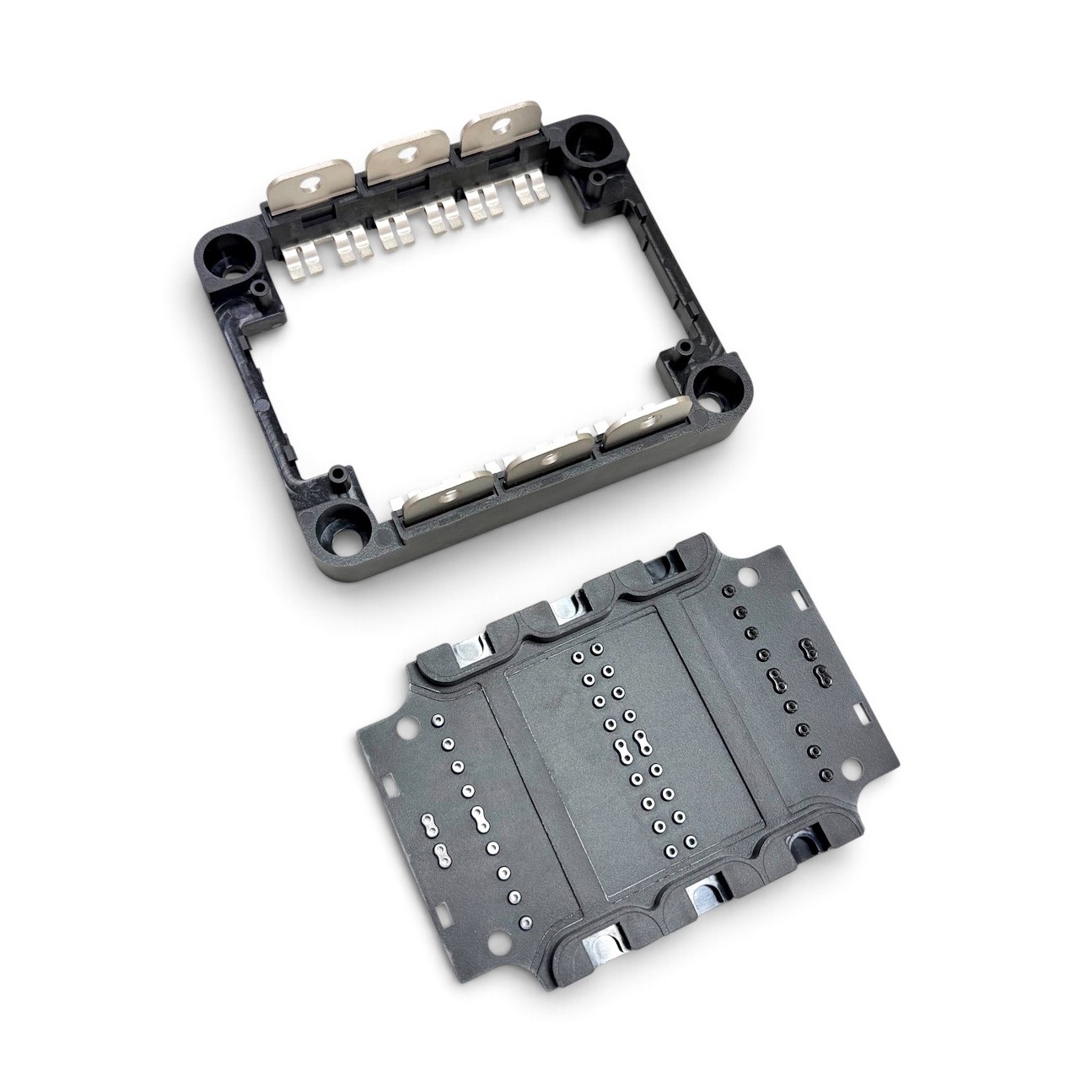 Separated power module frame and housing components showing metal inserts and precision plastic features