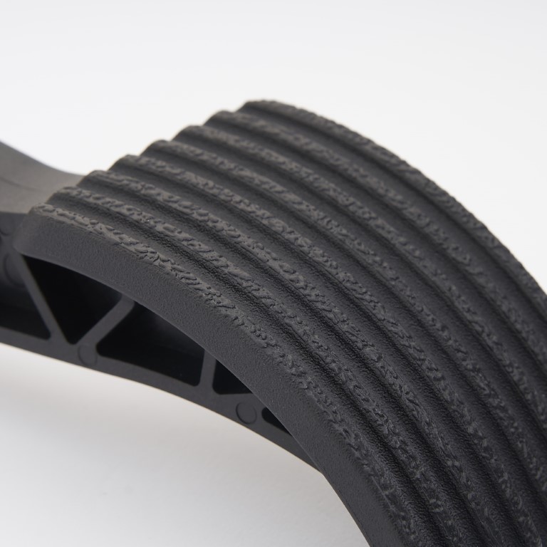 Injection molded plastic pedal pad with fine mold texture and anti-slip ribs